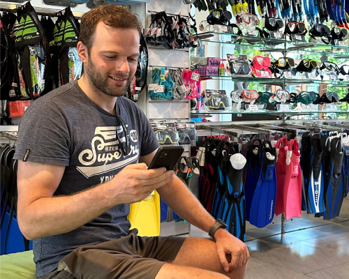 A customer digitally onboarding using a mobile phone, showcasing DiversDesk's expert dive center solutions.